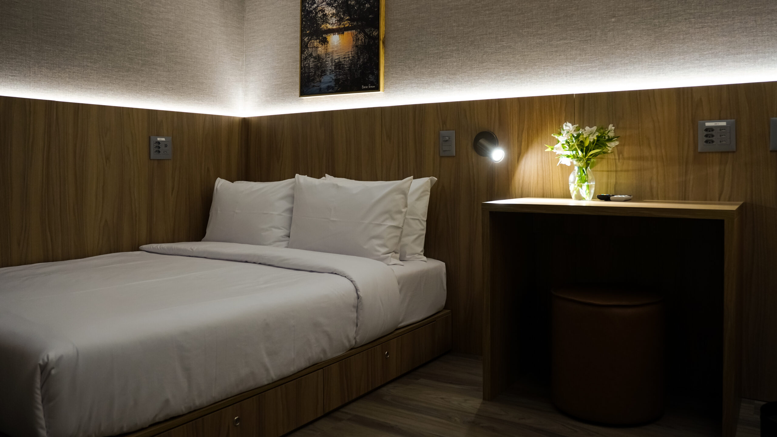 Acomodação elegante na sala VIP W Premium do Aeroporto de Fortaleza, com cama confortável, iluminação suave e ambiente projetado para descanso e praticidade.